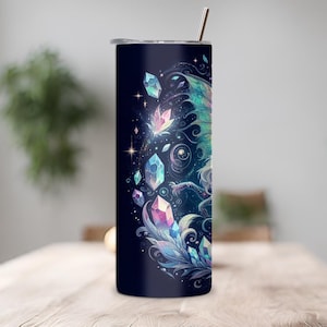 Op de afbeelding: Een roestvrijstalen tumbler met een donkerblauwe achtergrond en een kleurrijke illustratie van een draak met kristallen en sterren.