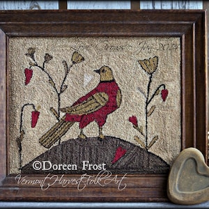 May include: A framed needlepoint artwork featuring a red bird with a gold tail perched on a brown mound. The bird is surrounded by green plants with red flowers. The artwork is signed "Doreen Frost Vermont Harvest Folk Art".