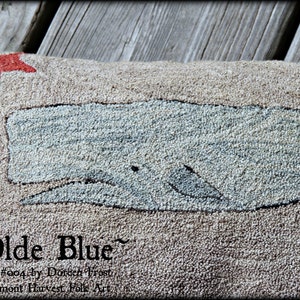Könnte beinhalten: Ein beige-blaues Nadelfilzkissen mit einem Walmotiv und dem Text "~Olde Blue~" und "PN #004 by Doreen Frost Vermont Harvest Folk Art".