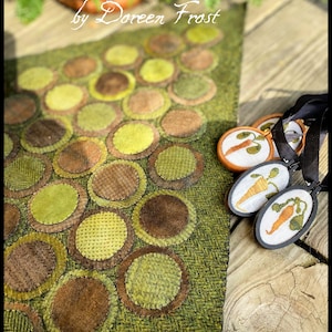 Puede incluir: Una alfombra de lana verde y marrón con un patrón de círculos. La alfombra se llama "Vermont Harvest Folk Art by Doreen Frost".