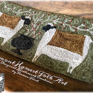 May include: Handmade rug featuring two stylized sheep with brown and white wool, set against a green background with red berry accents. The rug is labeled "Vermont Harvest Folk Art" with the artist's name.