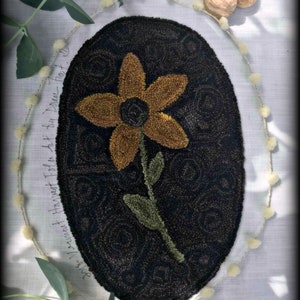 May include: A black and brown oval rug with a yellow flower design. The rug is surrounded by a white trim and the text "Vermont Harvest Folk Art" is written at the top of the image.