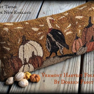 May include: A brown and tan needlepoint pillow with a turkey and pumpkins. The pillow has the text "Harvest Thyme In Olde New England" and "Vermont Harvest Folk Art By Doreen Frost".
