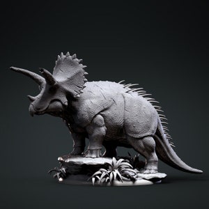 以下が含まれることがあります： グレーで詳細な3Dプリントされたトリケラトプスの恐竜のモデル。恐竜は、周囲に小さな植物のある岩の台座の上に立っています。