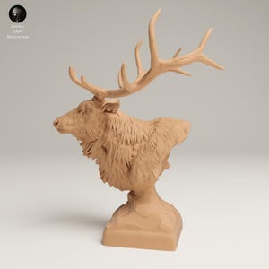 Puede incluir: Busto detallado de un alce, esculpido en un material marrón claro. El alce tiene grandes astas y una apariencia texturizada similar a la piel. La escultura está montada sobre una base rectangular, mostrando una representación realista del animal.
