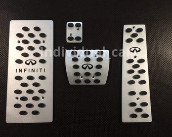 May include: Set of four silver metal car pedal covers with black rubber inserts. The covers feature the Infiniti logo and are designed to enhance the look and feel of the car's interior.
