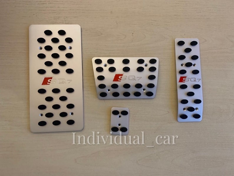 May include: Set of five silver-colored car pedal covers with black rubber inserts. Each cover has the red letters "SQ7" printed on it. The text "Individual_car" is printed at the bottom of the image.