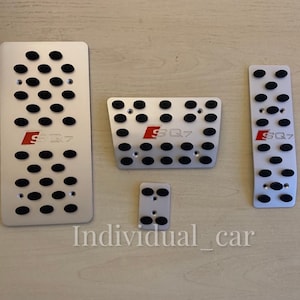 May include: Set of five silver-colored car pedal covers with black rubber inserts. Each cover has the red letters "SQ7" printed on it. The text "Individual_car" is printed at the bottom of the image.