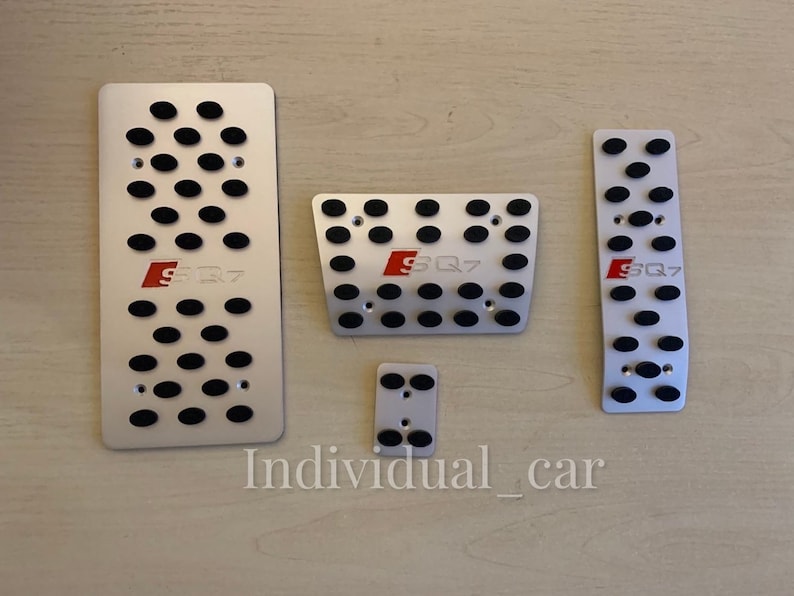 May include: Set of five silver-colored car pedal covers with black rubber inserts. Each cover has the red letters "SQ7" printed on it. The text "Individual_car" is printed at the bottom of the image.