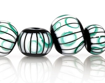 Teal rings under black stripes on white bead set, Contemporary patterns in glass, handmade lampwork beads by JC Herrell