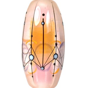 Puede incluir: Una cuenta de vidrio rosa y naranja con un diseño geométrico. La cuenta tiene una forma ovalada redondeada con líneas negras y acentos azules y amarillos. La cuenta es transparente, permitiendo el paso de la luz.