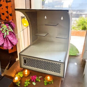 May include: A white wooden shelf unit with three shelves and a decorative lattice design on the front. The shelf unit is designed for displaying small items and has a small drawer at the bottom.