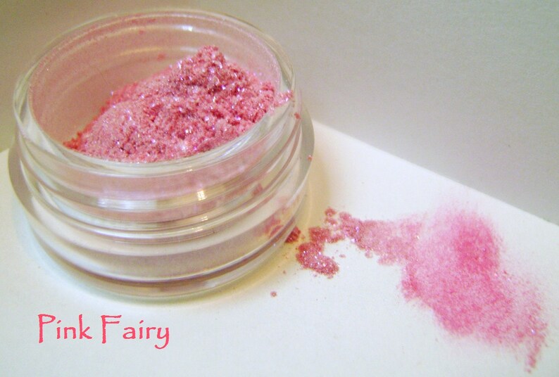May include: A small glass jar filled with pink glitter makeup. The jar is labeled "Pink Fairy".