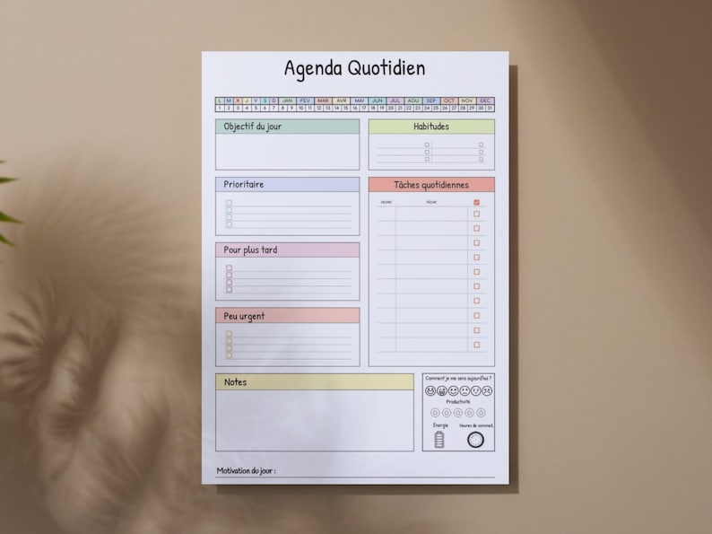 May include: A white daily planner with the title "Agenda Quotidien" at the top. It features sections for daily objectives, habits, tasks, and notes, with a color-coded layout. The planner is designed for daily use.