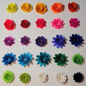 Könnte beinhalten: Fünfundzwanzig Papierblumen in verschiedenen Farben, darunter Gelb, Orange, Rot, Rosa, Lila, Blau, Grün, Weiß und Schwarz. Die Blumen sind in fünf Reihen mit jeweils fünf Blumen angeordnet.