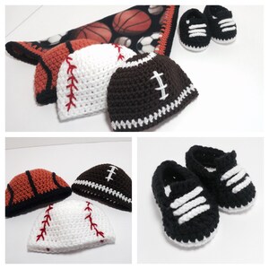 May include: Three crocheted baby hats in the shape of a baseball, football, and basketball. The hats are brown, white, and orange. There are also two pairs of black and white crocheted baby shoes.