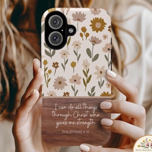 May include: A phone case with a floral pattern and a wooden back panel with the quote "I can do all things through Christ who gives me strength Philippians 4:13".