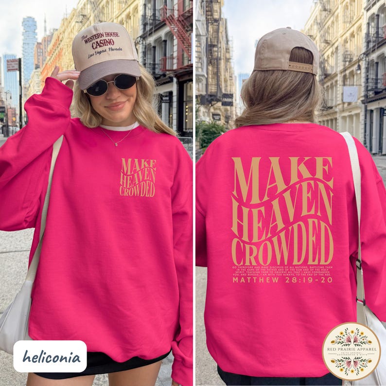 May include: A bright pink long-sleeve sweatshirt featuring the text "MAKE HEAVEN CROWDED" in a wavy gold font on the back, with a smaller version on the front left chest. The back also includes the scripture Matthew 28:19-20 in small gold text.