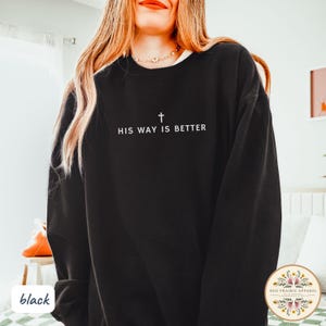 May include: Black sweatshirt with the text "HIS WAY IS BETTER" and a cross graphic. The sweatshirt is a crew neck style. The words and cross are in white. The sweatshirt is a solid black color.