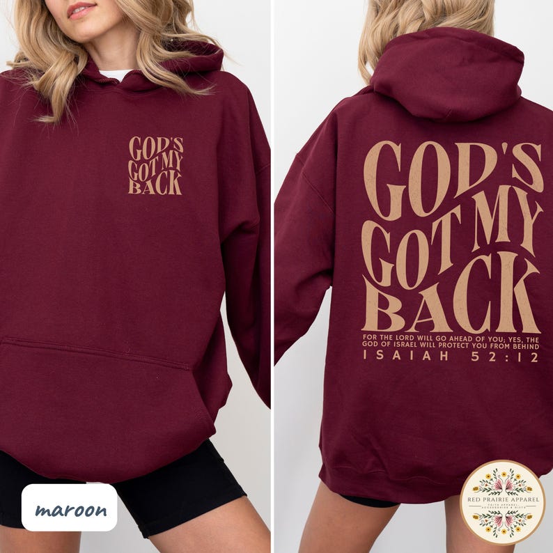 May include: Maroon hoodie with the text "GOD'S GOT MY BACK" in a tan color on the front and back. The back also features a Bible verse. The hoodie is a pullover style with a hood.