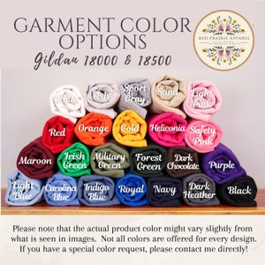 May include: Image showcasing a variety of rolled-up fabric samples in various colors, including white, red, orange, and green. The text "GARMENT COLOR OPTIONS" is at the top, with "Gildan 18000 & 18500" below. The Red Prairie Apparel logo is in the upper right corner.