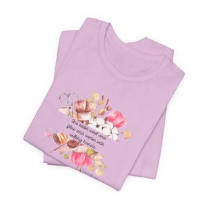 Proverbs 31:13 t shirt with images of pink, white and green knitting needles, crochet hooks, yarn and foliage.