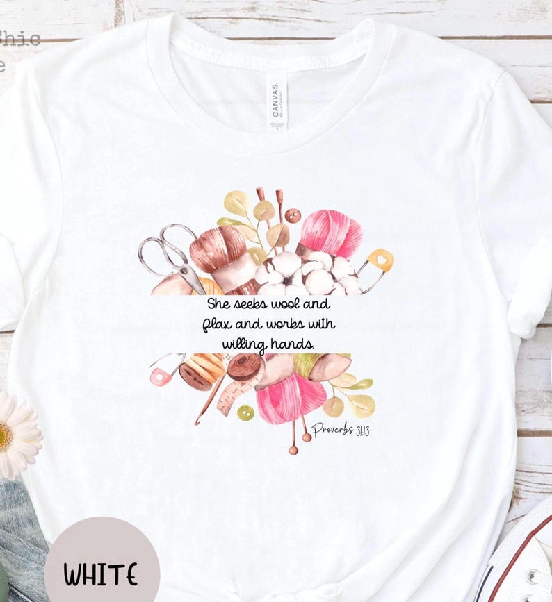 Proverbs 31:13 t shirt with images of pink, white and green knitting needles, crochet hooks, yarn and foliage.