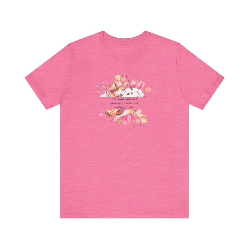 Proverbs 31:13 t shirt with images of pink, white and green knitting needles, crochet hooks, yarn and foliage.