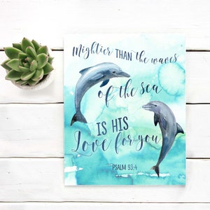 Könnte beinhalten: Ein Aquarellbild von zwei Delfinen, die aus dem Wasser springen, mit blauem und grünem Hintergrund. Der Text lautet "Mächtiger als die Wellen des Meeres ist seine Liebe zu dir - Psalm 93:4".