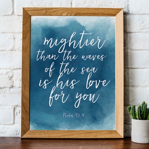 Könnte beinhalten: Gerahmter Kunstdruck mit dem Text "mightier than the waves of the sea is his love for you" in weißer Schrift auf blauem Aquarellhintergrund. Psalm 93,4 ist unten aufgedruckt.