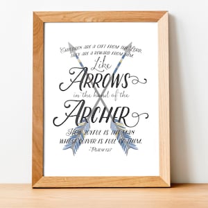 May include: A framed print with a white background and blue and gray arrows crossed in the center. The text reads "Children are a gift from the Lord, they are a reward from Him. Like Arrows in the hand of the Archer. How joyful is the man whose quiver is full of them. - Psalm 127"
