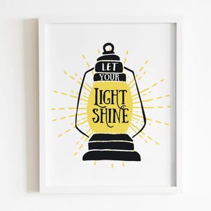 May include: A black and yellow printable wall art design featuring a lantern with the text "Let your light shine".