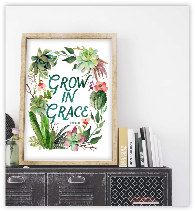 K&ouml;nnte beinhalten: Ein gerahmter Aquarelldruck mit einem gr&uuml;nen und wei&szlig;en Blumendesign. Der Druck zeigt den Text "Grow in Grace" mit dem Bibelvers "2 Peter 3:18".