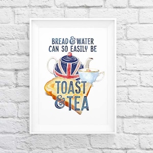Puede incluir: Una impresión enmarcada con una tetera con diseño de la bandera británica, una rebanada de tostada y una taza de té. El texto dice "Bread & water can so easily be Toast & Tea" en azul.