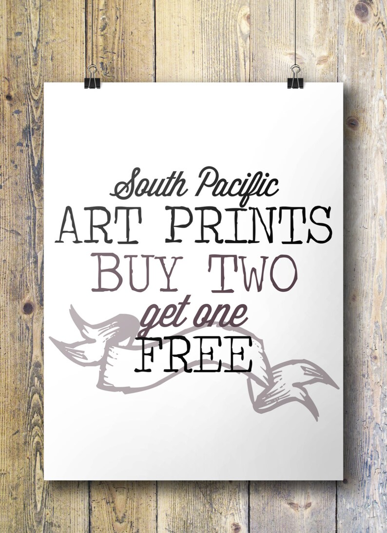 K&ouml;nnte beinhalten: Wei&szlig;es Schild mit schwarzem Text, der "South Pacific Art Prints Buy Two Get One Free" lautet. Unter dem Text befindet sich ein dekoratives Banner mit einem grau-wei&szlig;en Design.