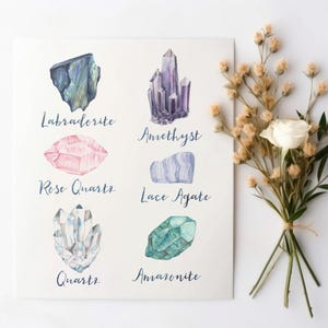 May include: Watercolor illustration of various crystals, including Labradorite, Amethyst, Rose Quartz, Lace Agate, Quartz, and Amazonite. Each crystal is labeled with its name in cursive script. A bouquet of dried flowers and a white rose is to the right.