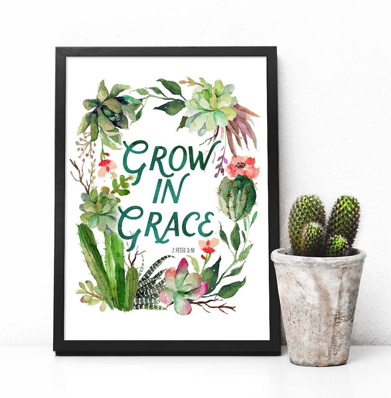 K&ouml;nnte beinhalten: Ein gerahmter Druck mit einer Aquarell-Illustration von Sukkulenten und Kakteen in einer Kranzform. Der Text "Grow in Grace" ist in gr&uuml;ner Schrift mit dem Schriftzitat "2 Petrus 3:18" darunter geschrieben.