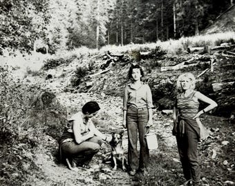 Foto vintage degli anni '70 di un'escursione in montagna nel bosco, tre donne e un cane, istantanea originale in bianco e nero, fotografia di avventura all'aria aperta.