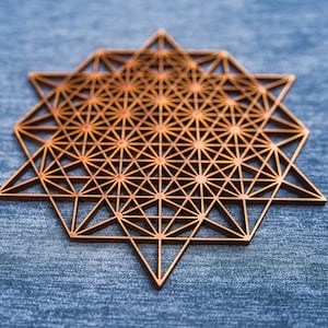 Puede incluir: Un diseño geométrico de madera con forma de estrella y detalles intrincados. El diseño está hecho de muchos triángulos y cuadrados pequeños, creando un patrón complejo.