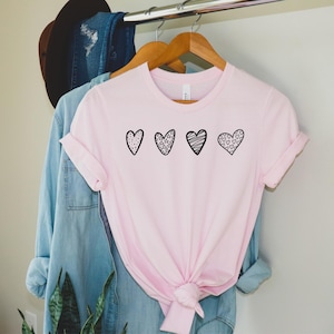 3 whimsical hand drawn hearts on a t-shirt.