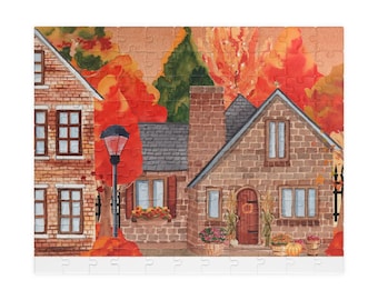 Puede incluir: Rompecabezas completo con una ilustración en acuarela de una escena otoñal. La imagen muestra casas de ladrillo, follaje otoñal en tonos rojos y naranjas y una farola. Las calabazas y las flores decoran la escena.