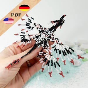 Pode incluir: Uma figura de dragão de contas pretas, brancas e vermelhas. O dragão tem asas abertas e uma cauda longa. A imagem inclui o texto "PDF" e as bandeiras dos Estados Unidos e da Alemanha.