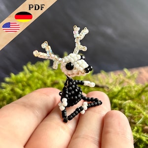 May include: A small, beaded reindeer figurine with black and white beads. The reindeer has large, white antlers and black eyes.