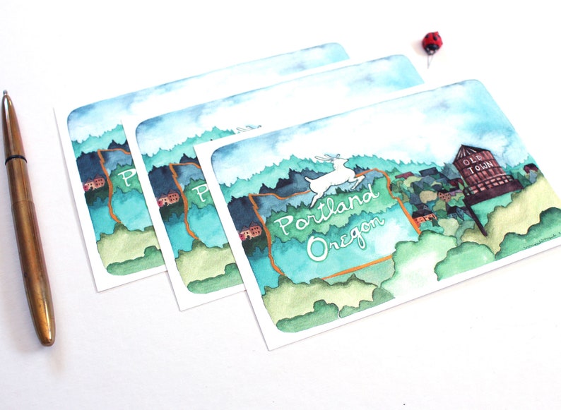 May include: Three watercolor postcards featuring a stylized illustration of the state of Oregon with the text "Portland Oregon" and a deer. The top postcard shows a water tower with the text "Old Town".