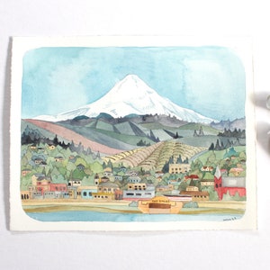 Puede incluir: Pintura acuarela de un pueblo con una montaña cubierta de nieve en el fondo. El pueblo está pintado en tonos de rojo, naranja, amarillo y verde. La montaña está pintada en tonos de azul y blanco. El cielo está pintado en tonos de azul y blanco. La pintura está firmada "Hannah 23".