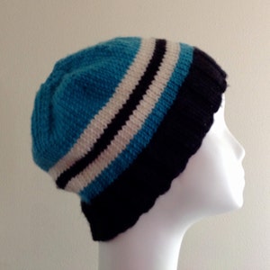 May include: A blue, white and black striped knitted beanie hat.