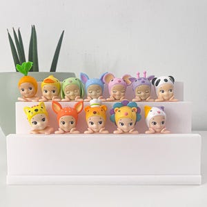 Tiered stand to display Sonny Angel Hippers without the need for adhesive. 3D printed 2-tier display case for up to 14 figures.