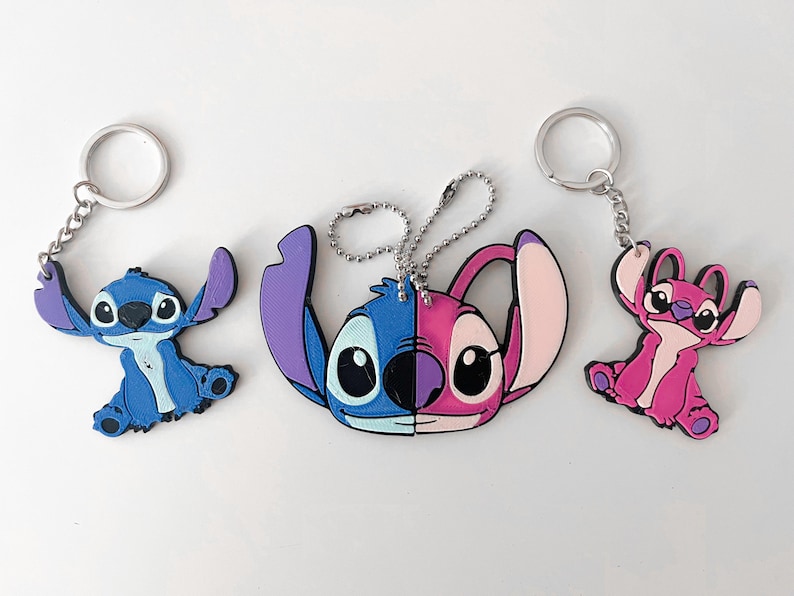 Pode incluir: Tr&ecirc;s chaveiros Stitch. Um chaveiro Stitch azul com um chaveiro prateado. Um chaveiro Stitch rosa com um chaveiro prateado. Um chaveiro com um Stitch azul e rosa com uma corrente prateada.