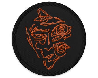 May include: A black embroidered patch with an orange outline of a face with multiple eyes.