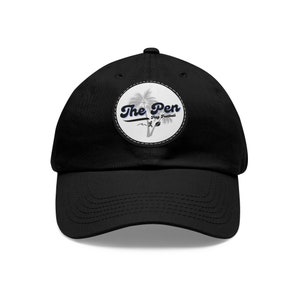 May include: Black baseball cap with a white patch featuring a palm tree and the text "The Pen Flag Football".
